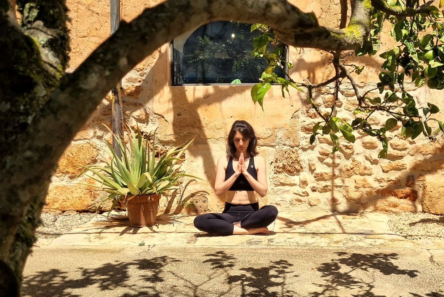 Morgane meditating in a sunny courtyard